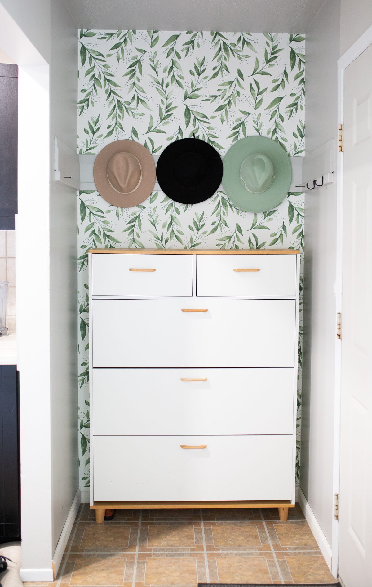 Botanical wallpaper, three hats, one dresser